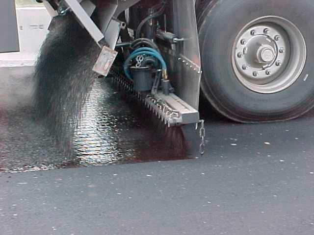 Distribuidor sincronizado aplicando emulsión y gravilla
